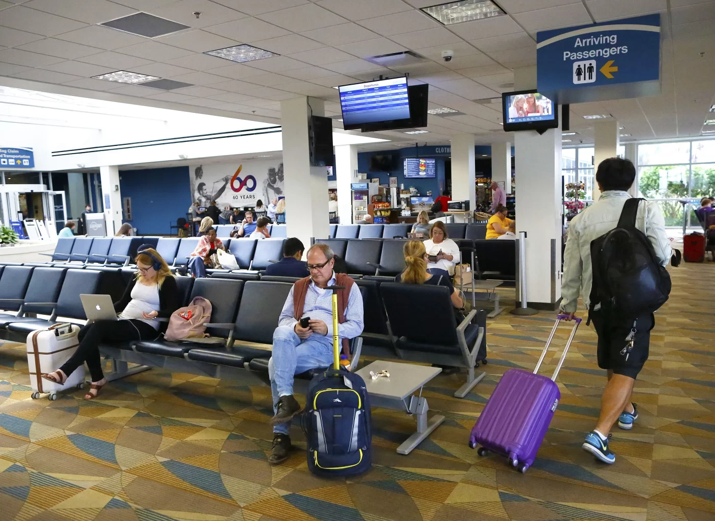 Travelers use devices and chat; American teen passes.
