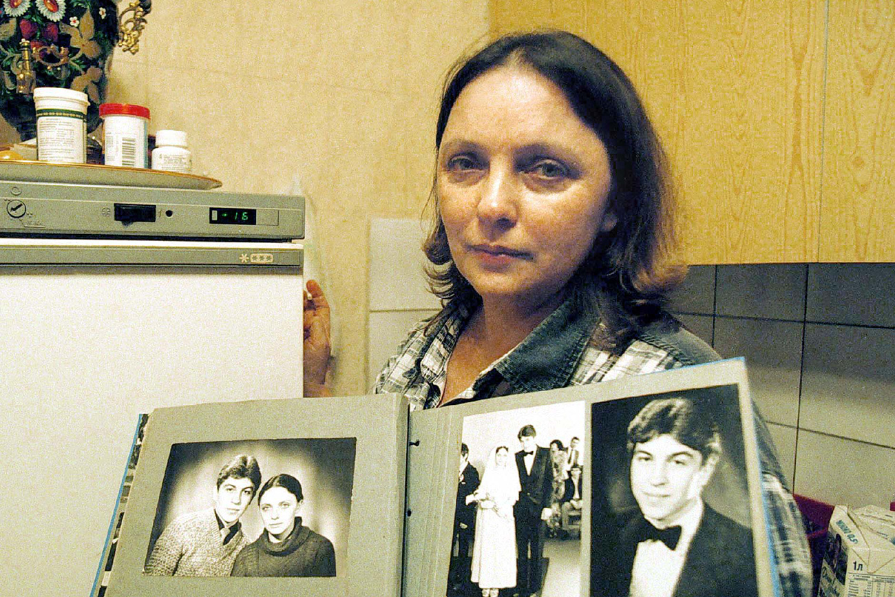 Savitskaya posing with photos of her deceased newlywed husband.